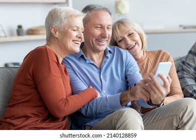 Positive Attractive Senior Man And Two Women Sitting On Couch At Nursing Home, Taking Selfie On Mobile Phone And Smiling, Happy Elderly Friends Having Fun Together, Closeup Portrait