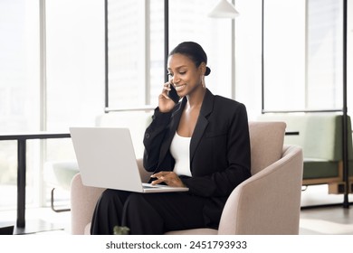 Positive beautiful African American business expert woman talking on mobile phone at laptop, using technology for job communication, enjoying professional telephone conversation - Powered by Shutterstock