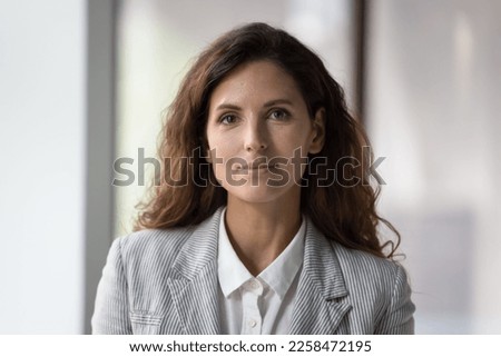 Positive beautiful millennial young businesswoman head shot face portrait. Confident pretty middle aged woman with black wavy hair, female business leader, company owner looking at camera, smiling