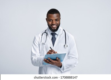 Positive Black Doc In White Robe With Stethoscope Collecting Patient Anamnesis Over White