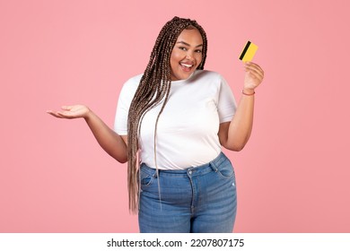 Positive Black Female Holding Credit Card Advertising Bank Offer Posing Smiling To Camera Standing Over Pink Background In Studio. Finances And Great Payment Service Concept - Powered by Shutterstock