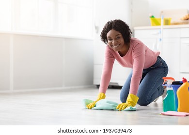 Positive Black Lady Cleaning Floor With Dust Cloth