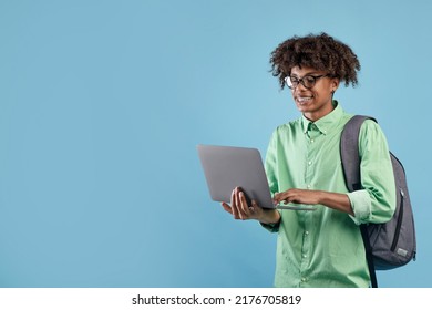 Positive black male student in casual outfit with backpack using modern laptop on blue studio background, enjoying nice educational website, copy space - Shutterstock ID 2176705819