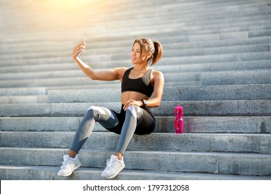 Positive black woman sport blogger taking selfie while exercising at park, resting and drinking water, free space - Powered by Shutterstock