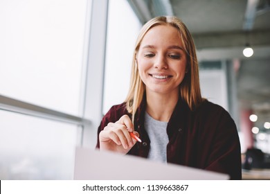 Positive blonde woman fill in information in questionnaire making application for hire on vacancy, smiling female students satisfied with know answers for test completing writing with pen indoors