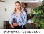 Positive businesswoman with briefcase for documents in office