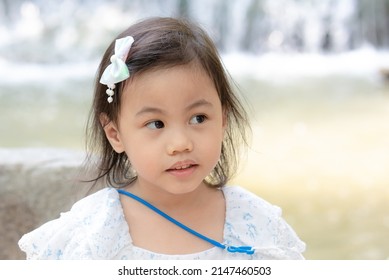 Positive Charming 4 Years Old Cute Baby Asian Girl, Little Preschooler Child Looking To The Right At Copy Space. Absent Minded Children.