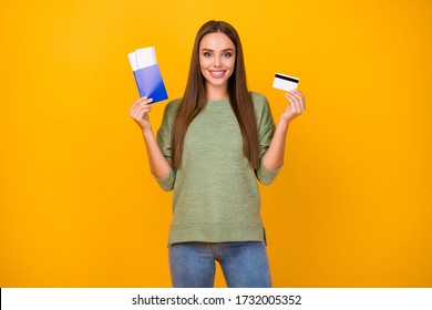 Positive cheerful girl hold tickets ready travel abroad tourism weekend pay her holiday with easy credit card banking system wear jumper denim isolated bright shine color background
