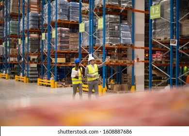 Positive cheerful warehouse workers checking organization and distribution of products in large storage area. Teamwork at warehouse. - Powered by Shutterstock