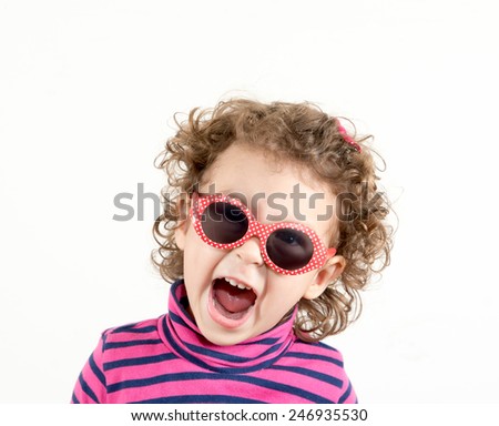 Positive child with retro sunglasses showing her happiness
