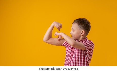 positive, confident Caucasian 8-year-old in shirt smiles and raises his clenched fists, flexing muscles in his arms, feeling strong and full energy after eating healthy protein lunch and working out - Powered by Shutterstock