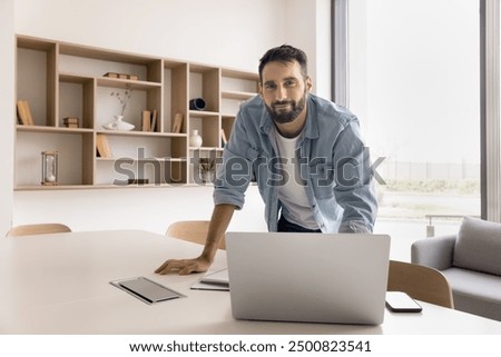 Similar – Image, Stock Photo Hispanic guy leaning on hand sitting against colorful illumination with opened mouth