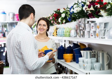 Positive Couple Buying Ceramic Tableware In Shop Cookware