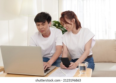 Positive Couple Managing Family Finances Via Form On Laptop And Filling Income Tax Forms Online