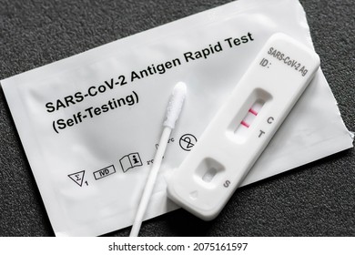 Positive Covid-19, SARS‑CoV‑2 antigen test kit for self testing, one step coronavirus antigen rapid test, saliva swab, 1 test box, close up - Shutterstock ID 2075161597