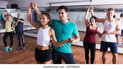 Positive Dancing Couples Learning Salsa At Dance Class