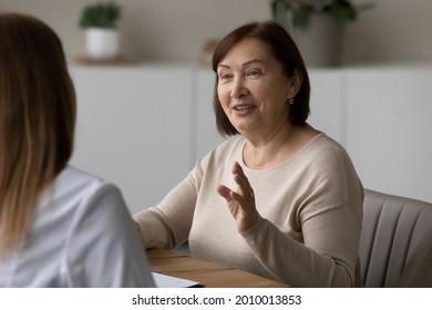Positive elder patient visiting doctor, consulting about healthcare problems, medical examination procedures, talking to physician in hospital office with friendly smile. Practitioner appointment