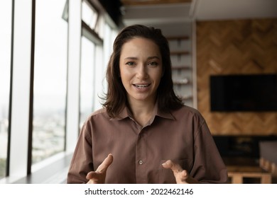 Positive engaged business woman looking at camera, speaking, smiling. Female coach, teacher talking to audience from screen, giving webinar, workshop via conference video call. Head shot portrait - Powered by Shutterstock