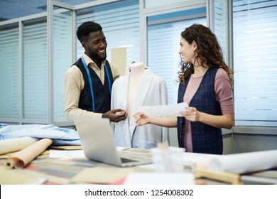 Positive excited young multi-ethnic colleagues of design studio working on jacket and discussing clothing design - Shutterstock ID 1254008302