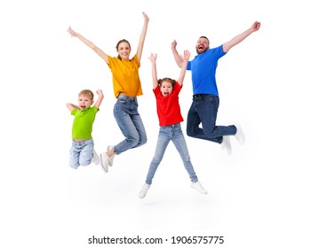 Positive family: couple and kids jumping with outstretched arms above ground in studio on white background while having fun and celebrating victory