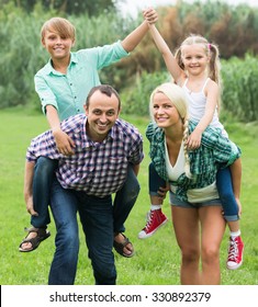 Positive family of four having fun at countryside in summer day   - Shutterstock ID 330892379
