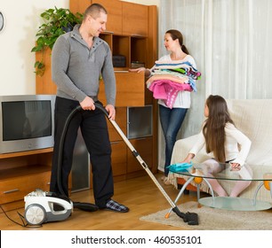 Positive Family Of Three Cleaning In The Living Room All Together. Focus On Man