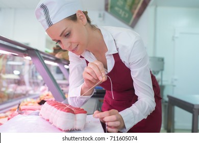 positive female butcher preparing product