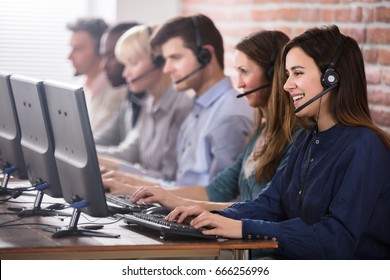 Positive Female Customer Services Agent With Headset Working In A Call Center - Shutterstock ID 666256996