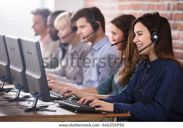 Positive Female Customer Services Agent With\
Headset Working In A Call\
Center