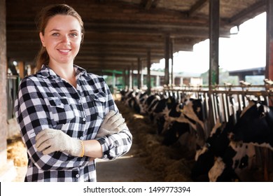 Positive Female Farmer Posing In Cowshed At Dairy Farm