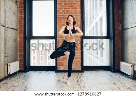 positive flexible girl doing yoga in the loft sport studio. hobby, interest, wellness, wellbeing