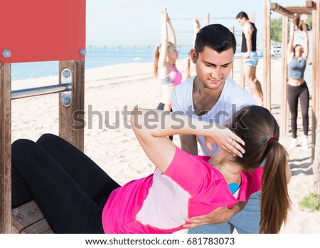 positive french people leading healthy lifestyle, doing exercises on ocean beach at daytime