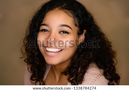 Positive, fun, happy attitude. Extremely happy young lady with curly hair and grinning broadly showing teeth while posing for the camera, fashion ringlight catchlight in eyes