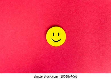 Positive Funny smiley face on a red cardboard background. Copy space for advertising and texts