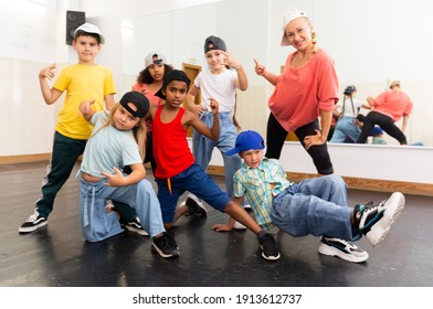 Positive Girls And Boys With Female Teacher Posing In Dance Studio During Hip Hop Class