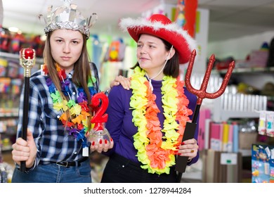Positive Girls Shopping Together, Showing Carnival Things In Store Of Festival Outfits And Accessories