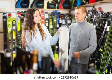 Positive Guy And Girl Are Choosing Skis In A Sports Equipment Store