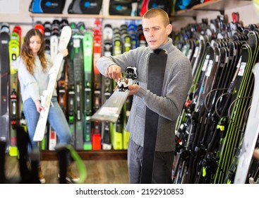 Positive Guy And Girl Are Choosing Skis In A Sports Equipment Store