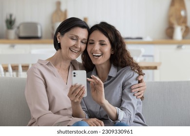 Positive happy adult child woman taking selfie on smartphone with cheerful mature mom, using device for Internet communication, video call, enjoying family relationship, leisure, friendship - Powered by Shutterstock