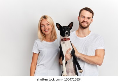 Positive Happy Couple With Dog Posing To The Camera Isolated Over White Background, Close Up Portrait, Studio Shot. Family With Favourite Pet. Lifestyle