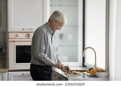 Positive happy senior mature chef man cooking healthy meal for dinner, cutting fresh vegetables, avocado, preparing natural ingredients, keeping healthy eating diet, lifestyle - Powered by Shutterstock