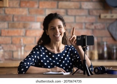 Positive Hispanic Female Motivational Speaker Record Video Coaching On Phone Point Finger Up Offer Interesting Idea. Smiling Young Woman Blogger Influencer Focus Audience Attention On Important Fact