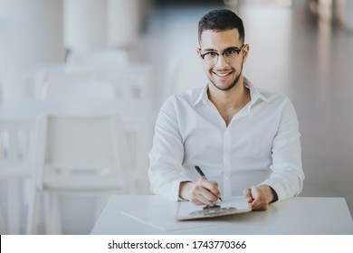 Positive HR Employee Sitting At A Desk At An Onboarding Meeting With Interns