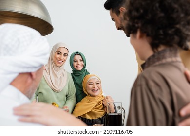Positive interracial muslim family with food hugging at home