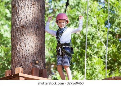 Positive Little Boy At Outdoor Treetop Adventure Park Being Active And Healthy