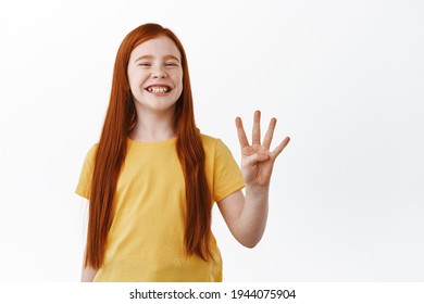 Positive Little Ginger Girl, Red Head Kid With Freckles Smiling Happy, Showing Number Four Fingers With Proud Pleased Face, Standing Over White Background