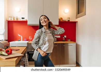 Positive Long-haired Woman Dancing In Kitchen, Distracted From Cooking Dinner