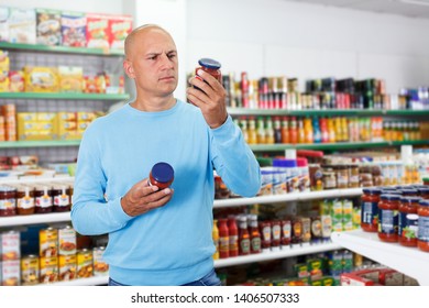 Positive male customer buying food products in grocery