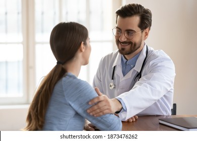 Positive Male GP Or Physician In White Medical Uniform Touch Female Patient Arm Show Empathy And Care. Smiling Caucasian Man Doctor Support Woman Client At Consultation In Hospital Or Clinic.