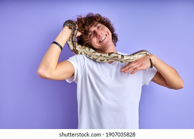 Positive Male Holding Snake In Hands, Doesn't Afraid, No Phobia. Caucasian Male In White T-shirt Posing With Snake